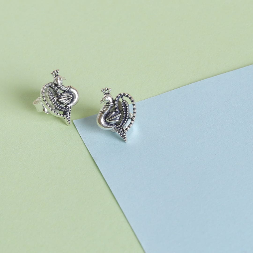 Embrace the allure of self-discovery with these exquisite handcrafted peacock studds. Made from sterling silver, they radiate timeless elegance and charm, perfect for enhancing your everyday style. Let these delicate earrings be a reflection of your unique beauty, celebrating both sophistication and simplicity. Elevate your jewelry collection with a touch of grace and confidence.