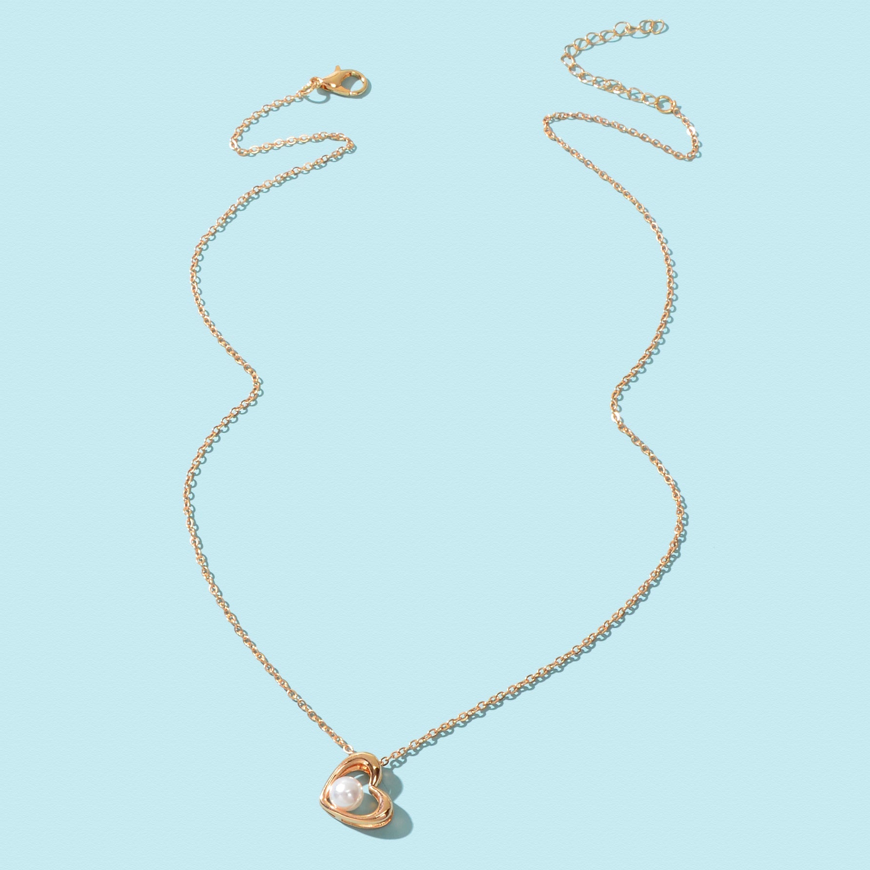 Embrace the allure of everyday elegance with this delicate golden chain necklace. The heart-shaped pendant, adorned with an imitation pearl, symbolizes love and connection. Perfect for expressing affection to a girlfriend, best friend, or mother, this piece adds a touch of grace to any office attire or casual ensemble. Celebrate your unique beauty and the bonds that enrich your life with this charming accessory.