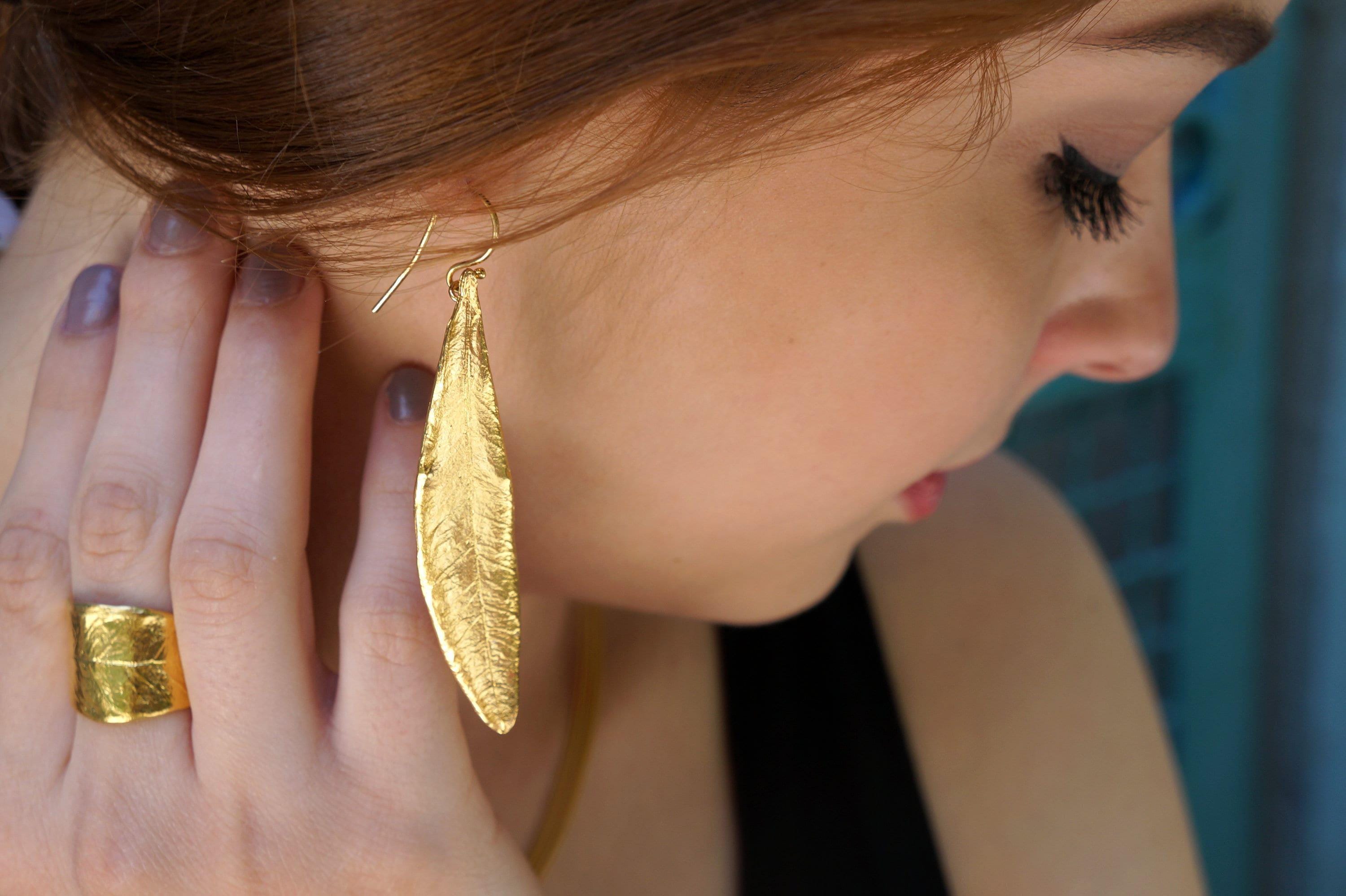 Embrace your essence with the Olive Leaf Dangle Earrings, where nature's beauty meets handcrafted elegance. Adorn yourself with these exquisite pieces, each capturing the delicate grace of olive leaves. Finished in radiant gold or silver, they symbolize peace and protection, inviting you to wear your intentions with pride. Perfect for celebrating your unique journey or gifting to someone special, these earrings are a reminder that true beauty lies in authenticity and self-love.
