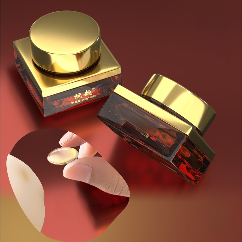 Two elegantly designed jars with gold lids sit gracefully, while a capsule is delicately held between fingers, embodying the essence of intimacy and self-discovery.