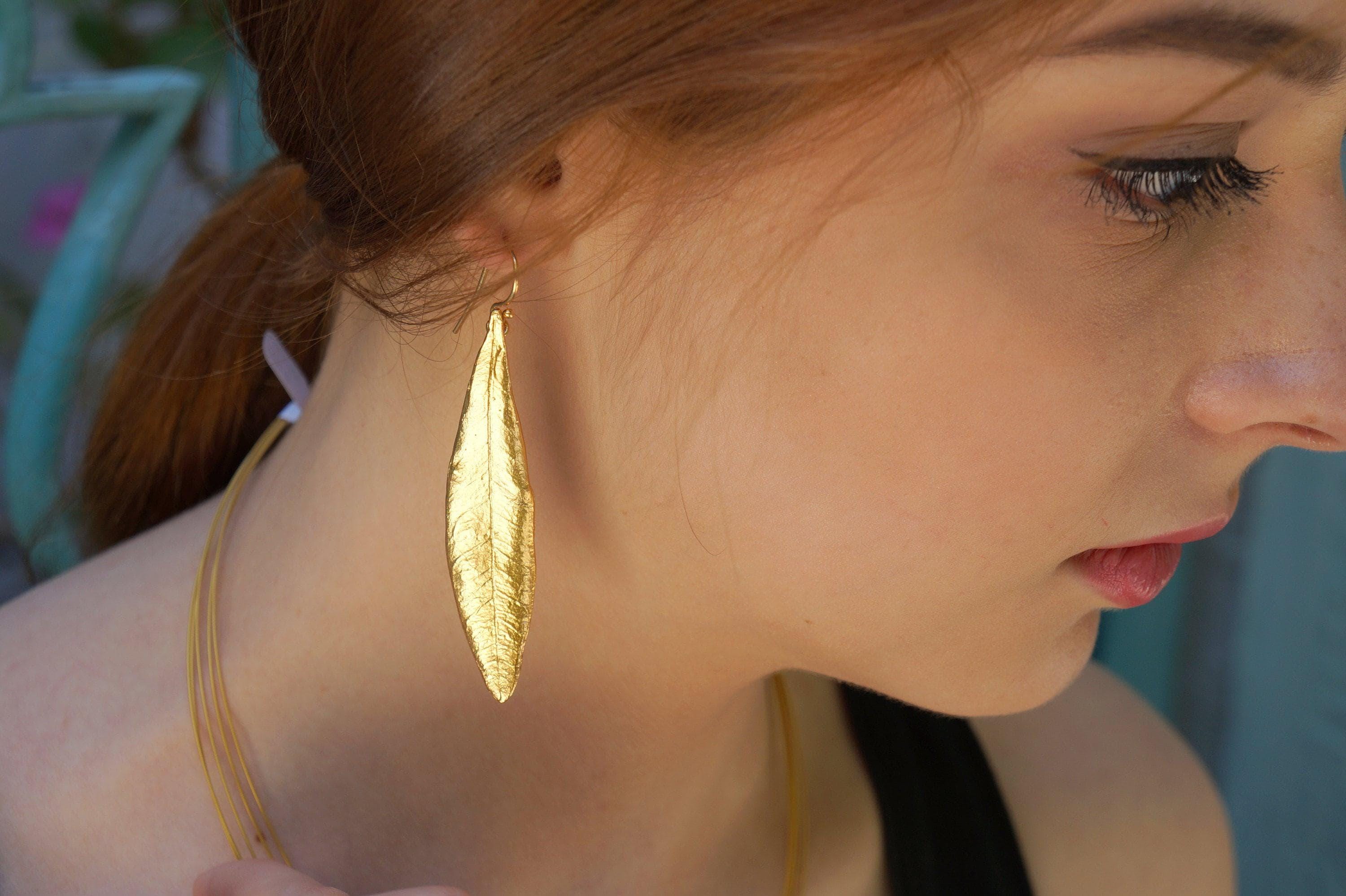 Embrace your sensuality with the Olive Leaf Dangle Earrings, a delicate blend of nature and elegance. Handcrafted to reflect the beauty of olive leaves, these earrings are more than an accessory; they are a symbol of peace and intention. Adorn yourself with a piece that celebrates your unique journey and empowers your self-expression. Perfect for those who seek to wear their story with grace and meaning.